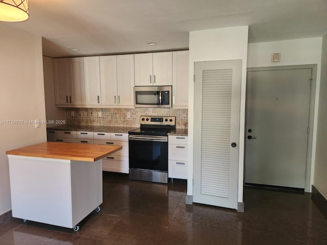 kitchen with appliances with stainless steel finishes, white cabinets, wooden counters, and tasteful backsplash