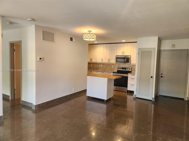 kitchen featuring granite finish floor, baseboards, visible vents, and stainless steel appliances