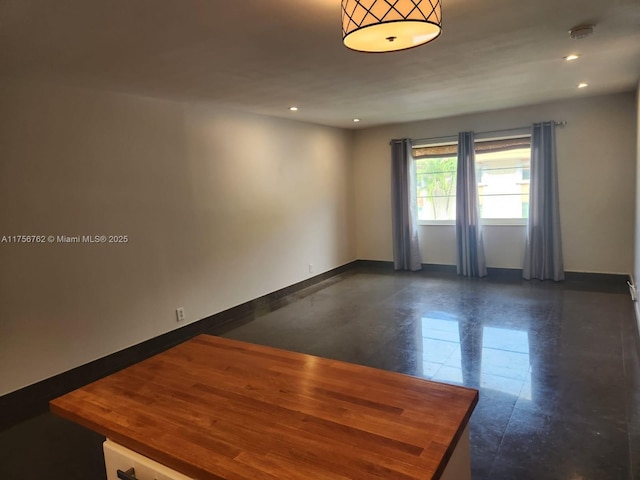 unfurnished room with recessed lighting and baseboards