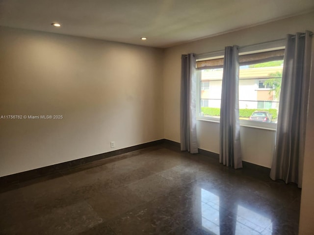 spare room featuring baseboards and recessed lighting