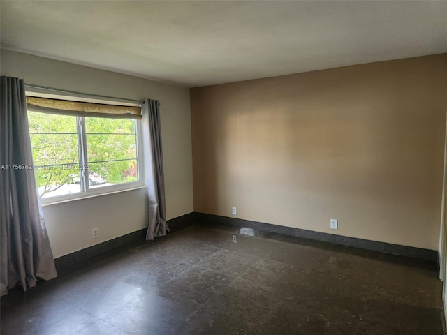 unfurnished room with baseboards