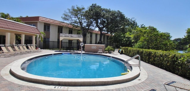 community pool featuring a patio area and fence