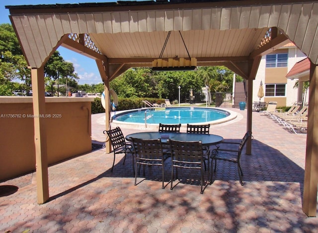 pool with outdoor dining area, a patio, a gazebo, and fence