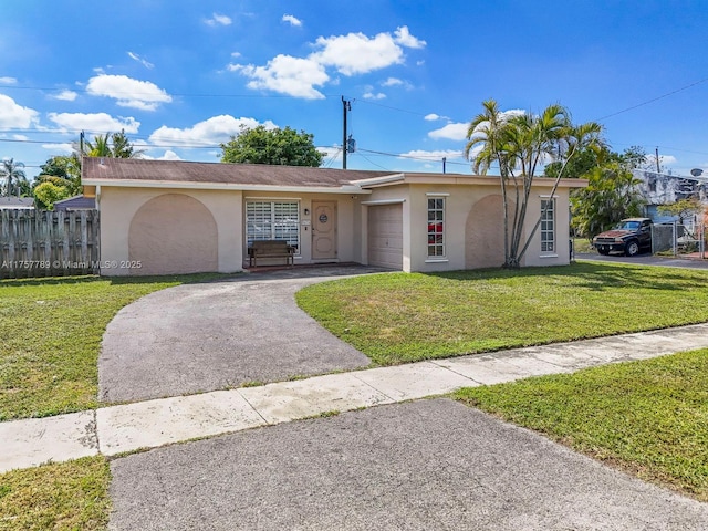 ranch-style house with a garage, fence, driveway, stucco siding, and a front lawn