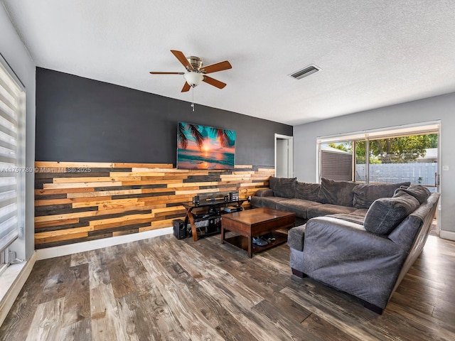 living area featuring a textured ceiling, visible vents, and wood finished floors