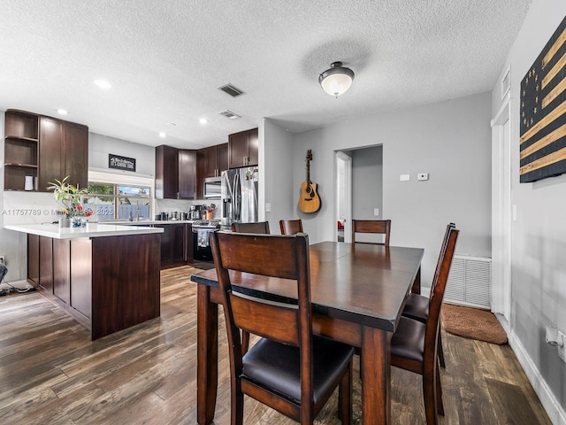 dining area featuring baseboards, visible vents, and dark wood-style flooring