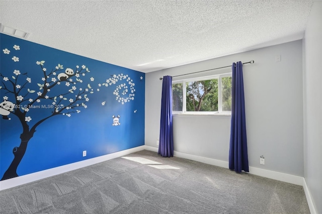 unfurnished room featuring carpet floors, visible vents, baseboards, and a textured ceiling