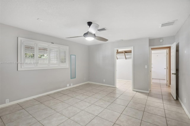 unfurnished room featuring light tile patterned floors, ceiling fan, visible vents, and baseboards