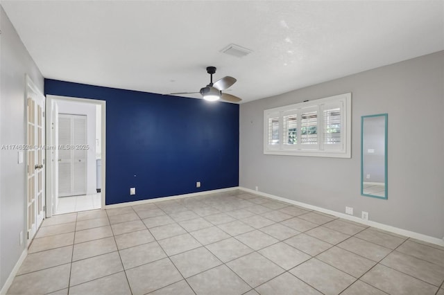 spare room with visible vents, ceiling fan, and baseboards