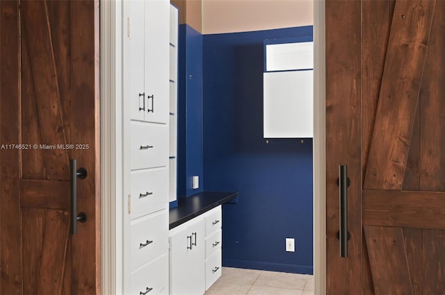 kitchen with dark countertops, light tile patterned floors, and white cabinets