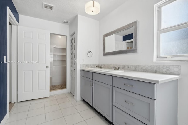 bathroom featuring visible vents, vanity, a textured ceiling, and tile patterned floors