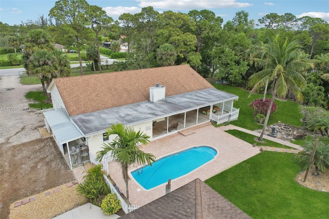 pool with a patio area, a lawn, and fence