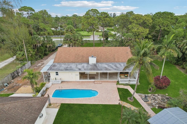 pool featuring a patio area, fence, and a lawn