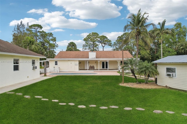 rear view of property with a chimney, a lawn, a patio area, and cooling unit