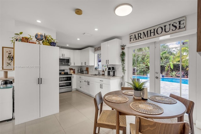 kitchen with white cabinets, appliances with stainless steel finishes, light countertops, and decorative backsplash