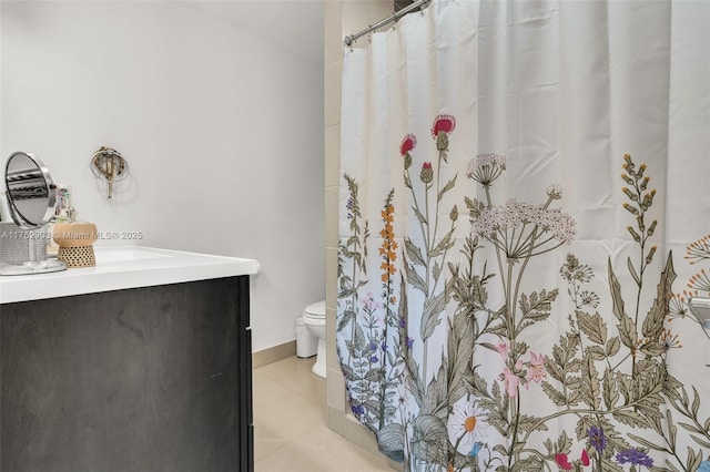 bathroom with toilet, curtained shower, tile patterned flooring, and vanity