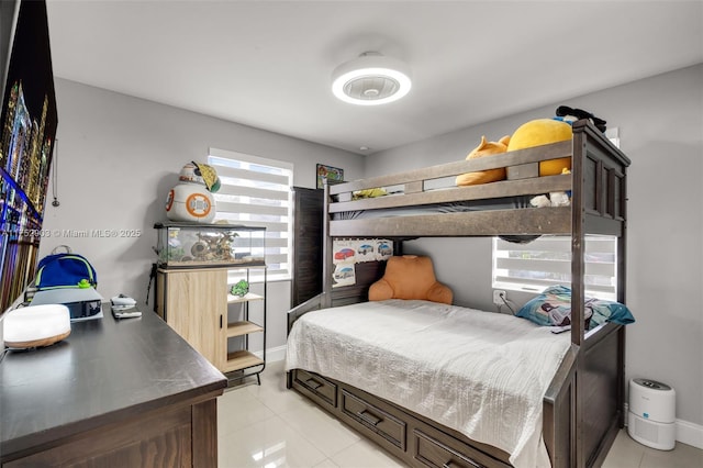 bedroom featuring light tile patterned flooring and baseboards