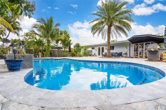 view of swimming pool featuring a patio, fence, a fenced in pool, and french doors