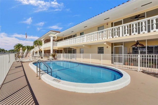 pool featuring fence and a ceiling fan