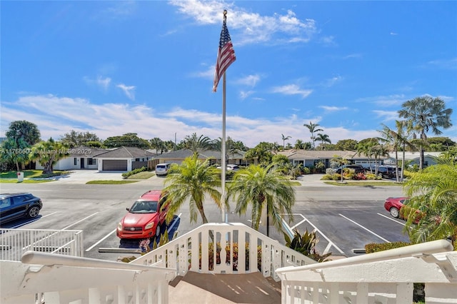 uncovered parking lot featuring a fenced front yard and a residential view