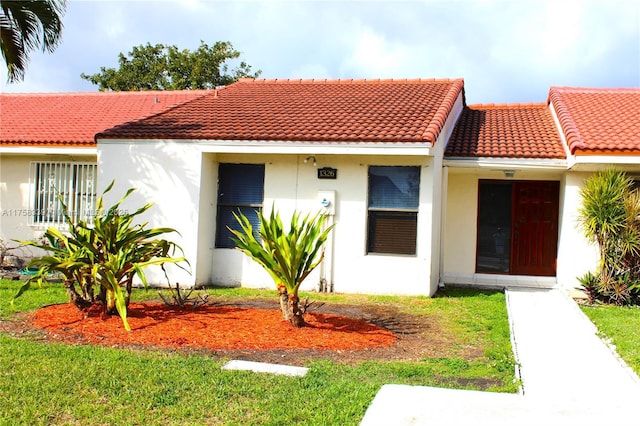 mediterranean / spanish house featuring a tile roof and stucco siding