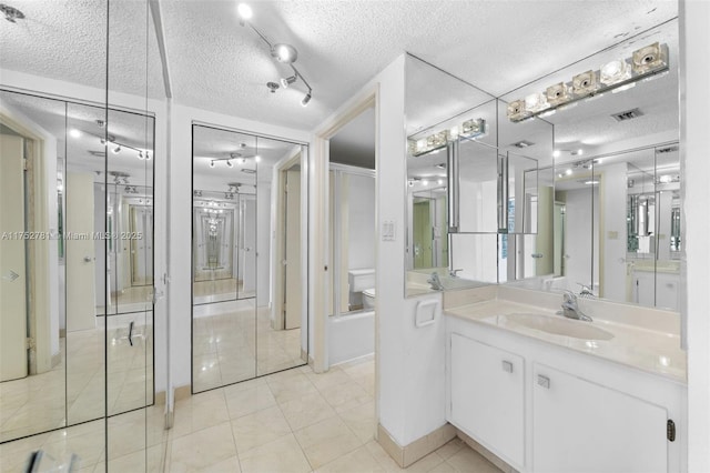 bathroom with visible vents, toilet, tile patterned floors, a textured ceiling, and vanity