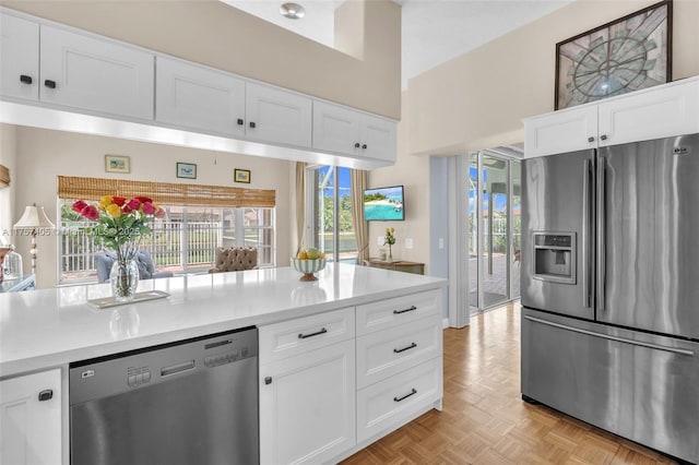 kitchen with stainless steel appliances, white cabinets, and light countertops