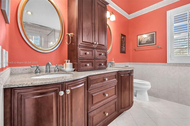 bathroom featuring a sink, tile walls, toilet, and tile patterned floors