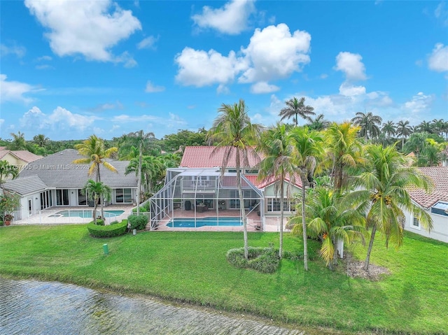 rear view of property with an outdoor pool, glass enclosure, a tile roof, a water view, and a yard