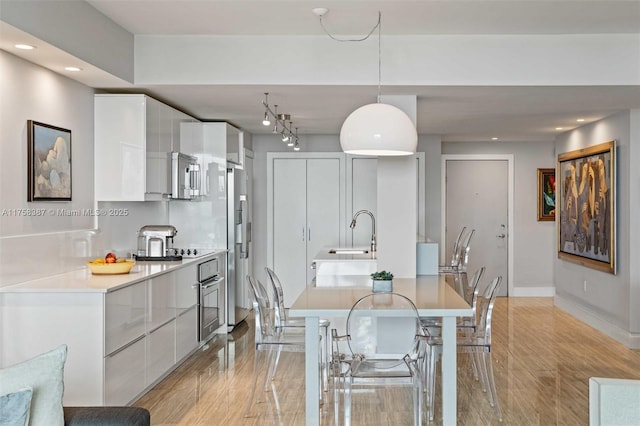 dining area featuring light wood-type flooring, baseboards, and recessed lighting