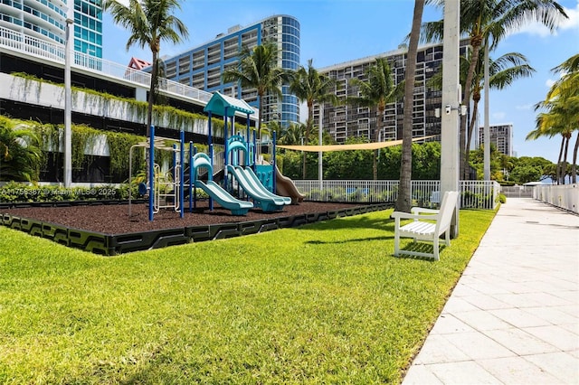 communal playground featuring fence and a yard