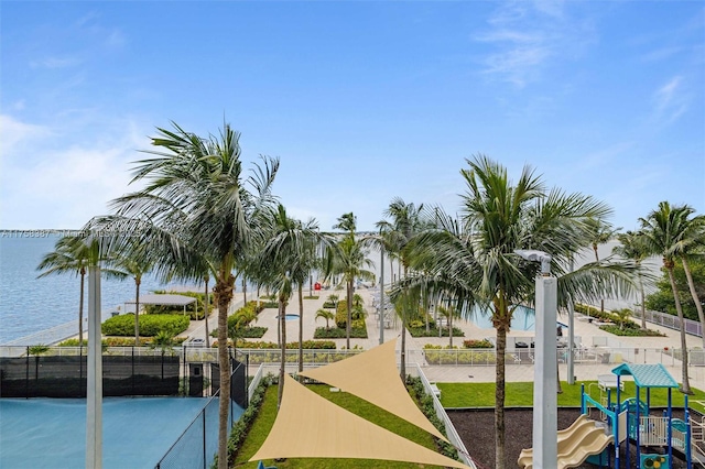 view of home's community with a water view, fence, and playground community