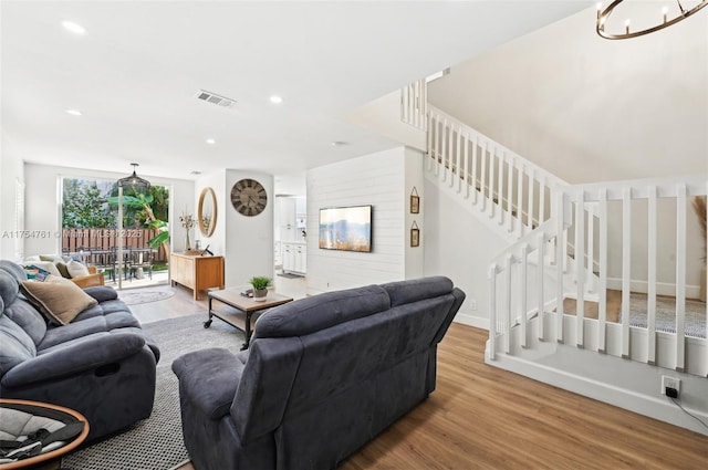 living area featuring visible vents, wood finished floors, recessed lighting, stairway, and a chandelier