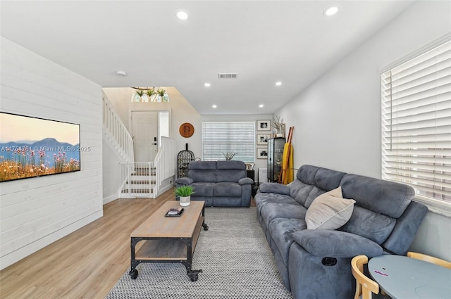 living area with recessed lighting, visible vents, wood finished floors, and stairs