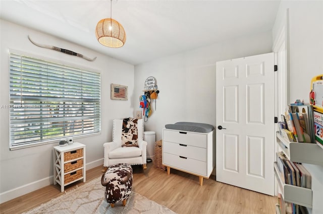 sitting room with baseboards and light wood-style floors