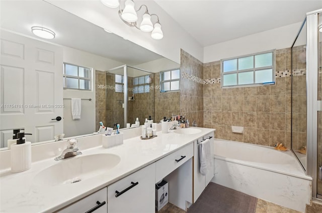 bathroom with double vanity, tiled shower, a tub, and a sink