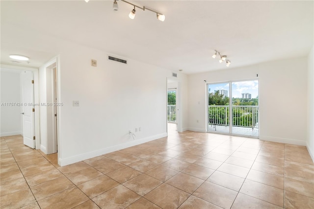 empty room with visible vents, baseboards, and light tile patterned floors