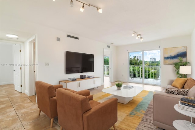 living area featuring track lighting, visible vents, and light tile patterned floors