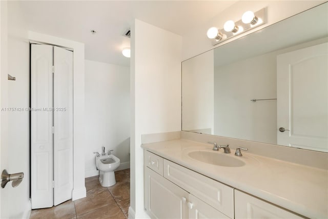 bathroom featuring baseboards, tile patterned flooring, vanity, a bidet, and a closet