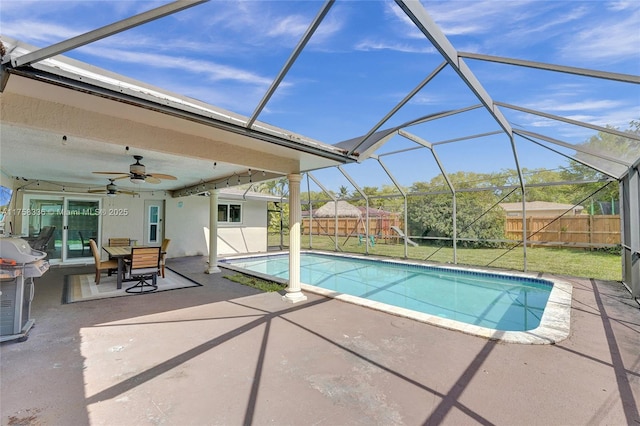 view of swimming pool with a fenced backyard, ceiling fan, a fenced in pool, a patio, and glass enclosure