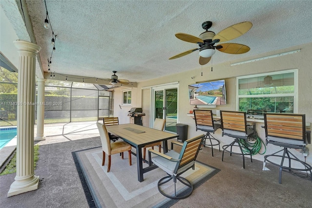 sunroom / solarium with ornate columns, a ceiling fan, and track lighting