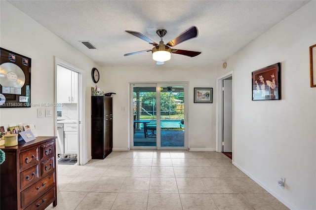 interior space with baseboards, visible vents, ceiling fan, and a textured ceiling