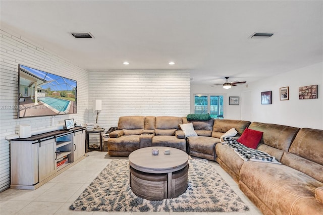 living room with light tile patterned floors, brick wall, visible vents, and recessed lighting