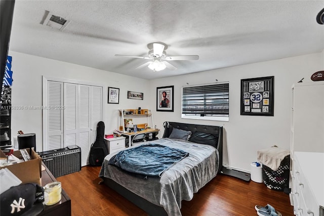 bedroom with a closet, ceiling fan, visible vents, a textured ceiling, and wood finished floors