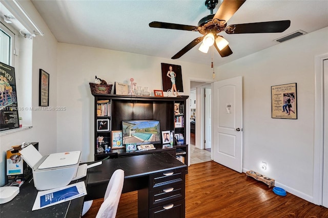 home office with baseboards, wood finished floors, visible vents, and a ceiling fan