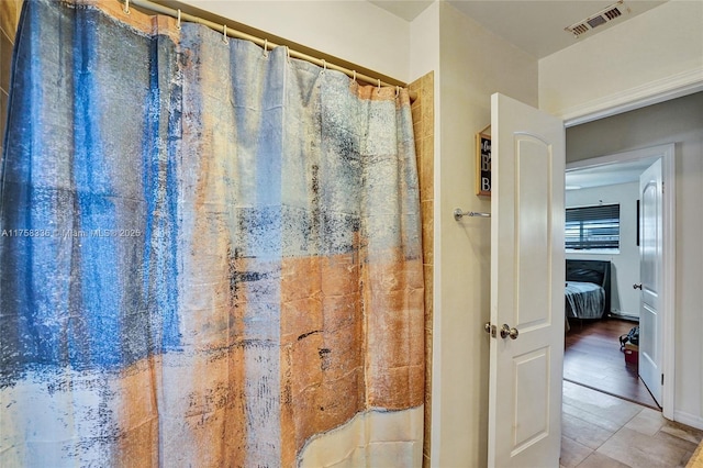 bathroom with a shower with shower curtain and visible vents