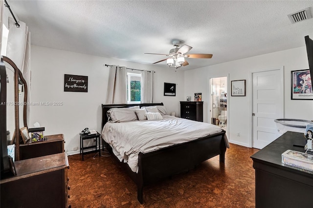 bedroom with a textured ceiling, ceiling fan, connected bathroom, visible vents, and baseboards