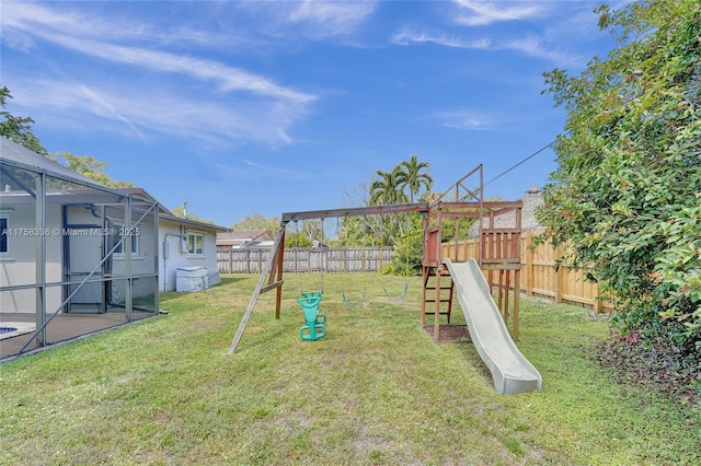 view of playground featuring glass enclosure, a lawn, and a fenced backyard