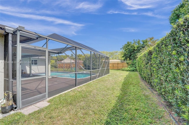 view of yard featuring a patio area, a fenced backyard, a fenced in pool, and a lanai