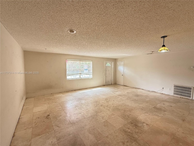 empty room with visible vents and a textured ceiling